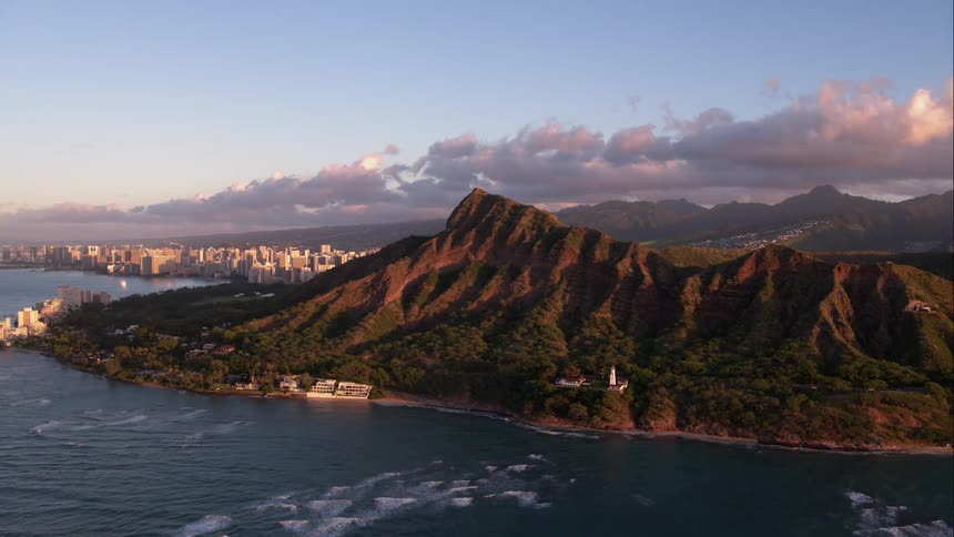 Mountains with water in foreground and clouds in background at dawn