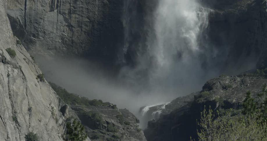 Waterfall splashes and mists down into a pool below