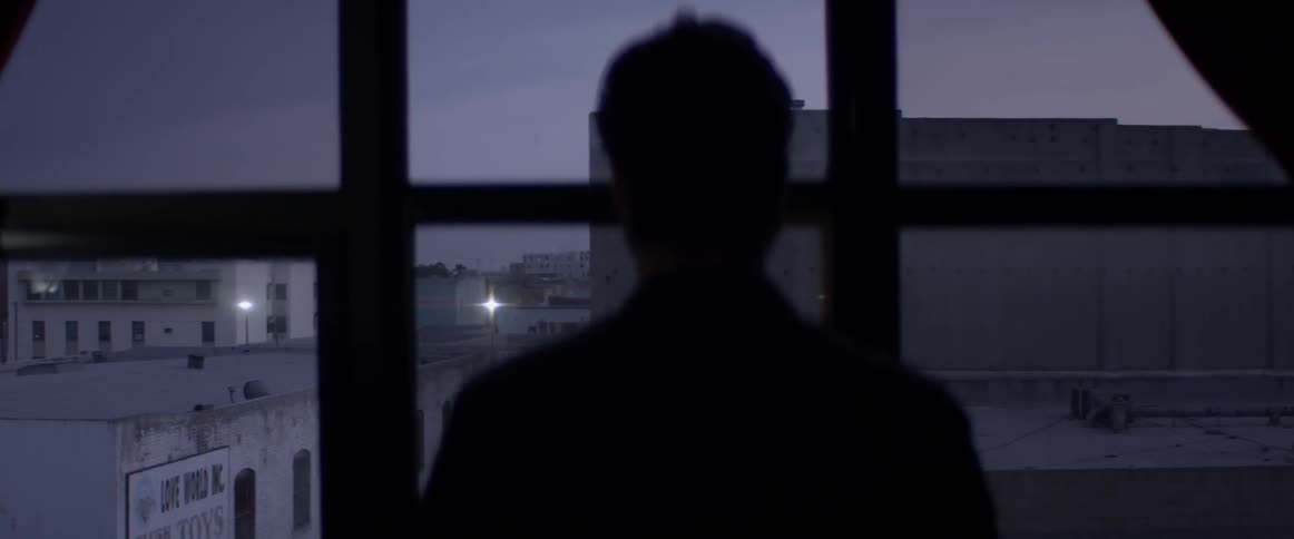 A man that is looking out on a city at night