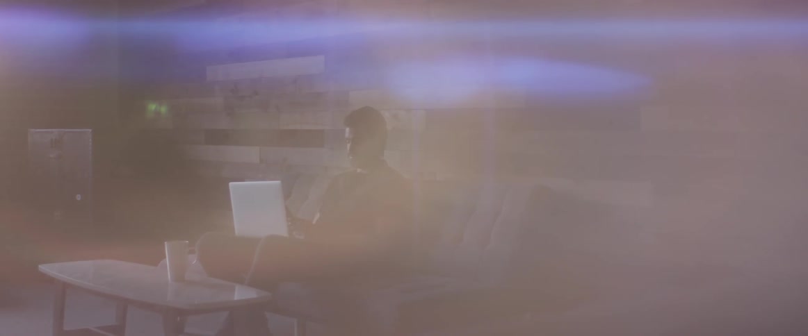 A man sitting on a couch using a laptop