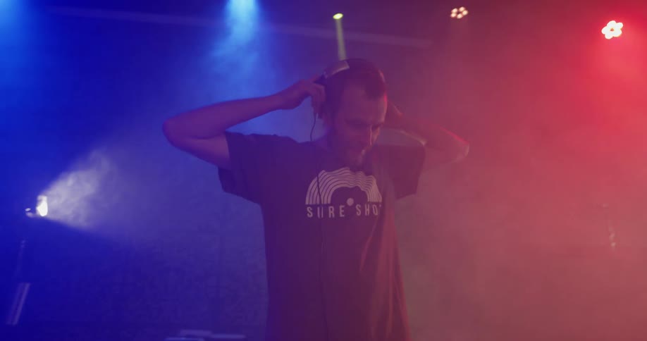Dj mixes while lights strobe and fog rolls in
