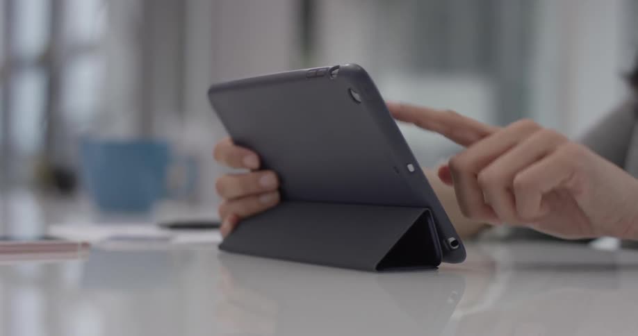Person using a tablet on a white table