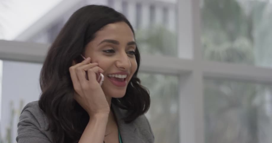 A woman talking on a cell phone in an office
