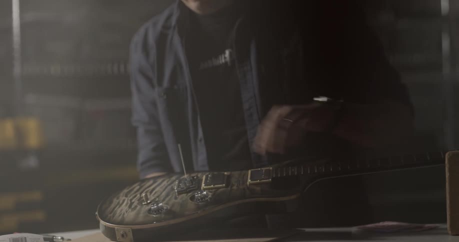 A man strings an electric guitar