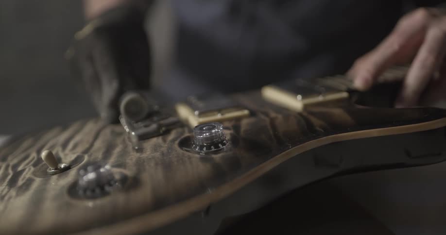 Man Making Guitar In Workshop