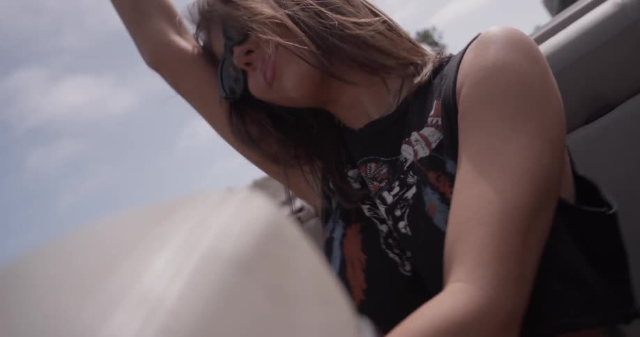 Two women dancing in the back of a convertible