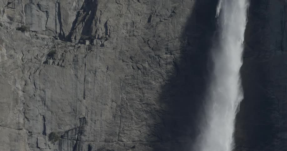 A waterfall barrels down the side of a cliff