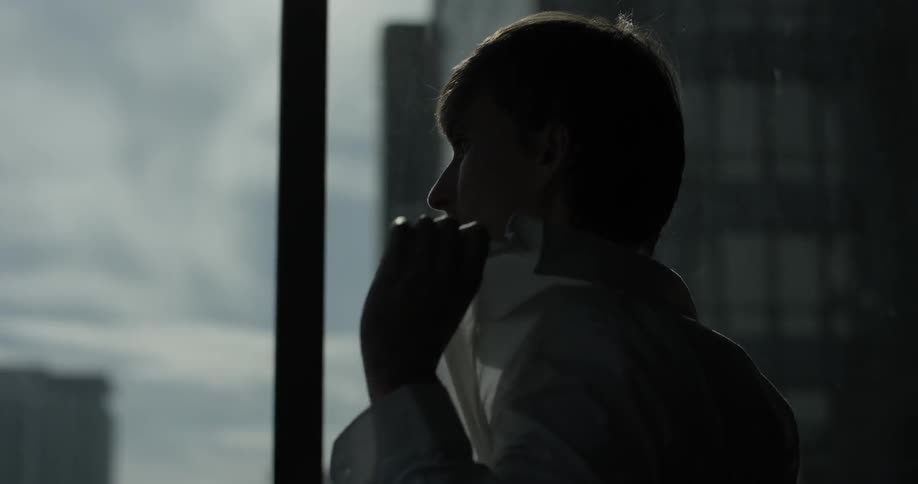 A man is looking out the window