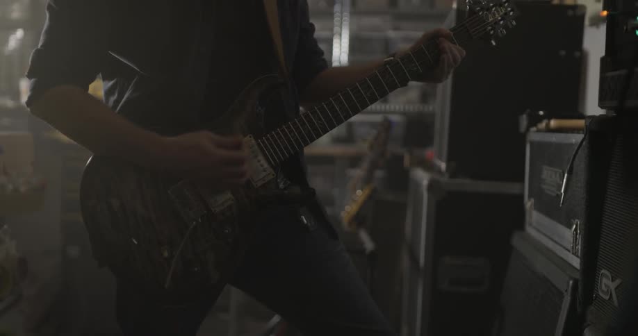 Man Making Guitar In Workshop