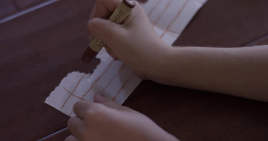 A child drawing lines on a scrap of paper
