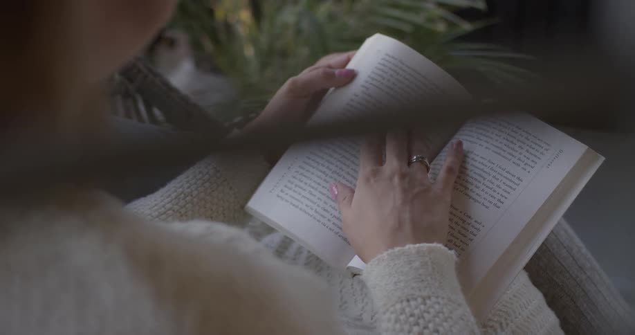 Woman reading a book while sitting outside
