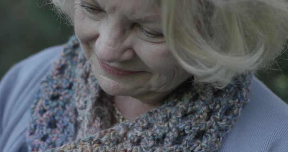 Older woman smiles while looking at something