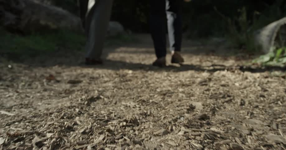 Two people walk a trail outside