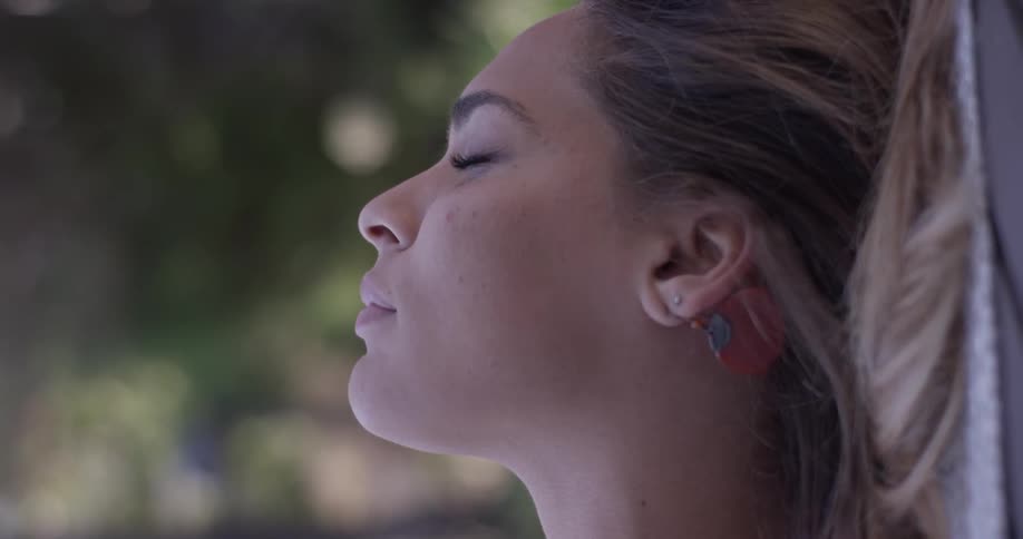 Woman lays outside with her eyes closed