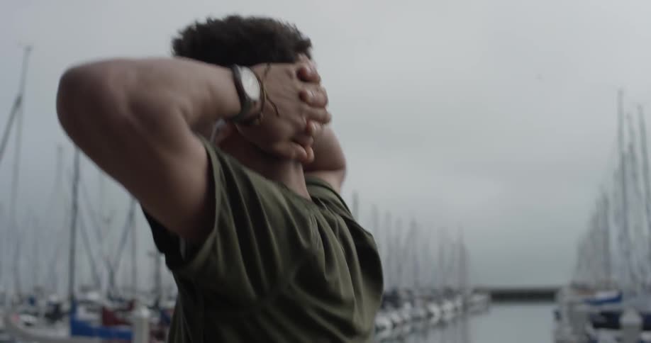 A man wearing headphones is walking outside