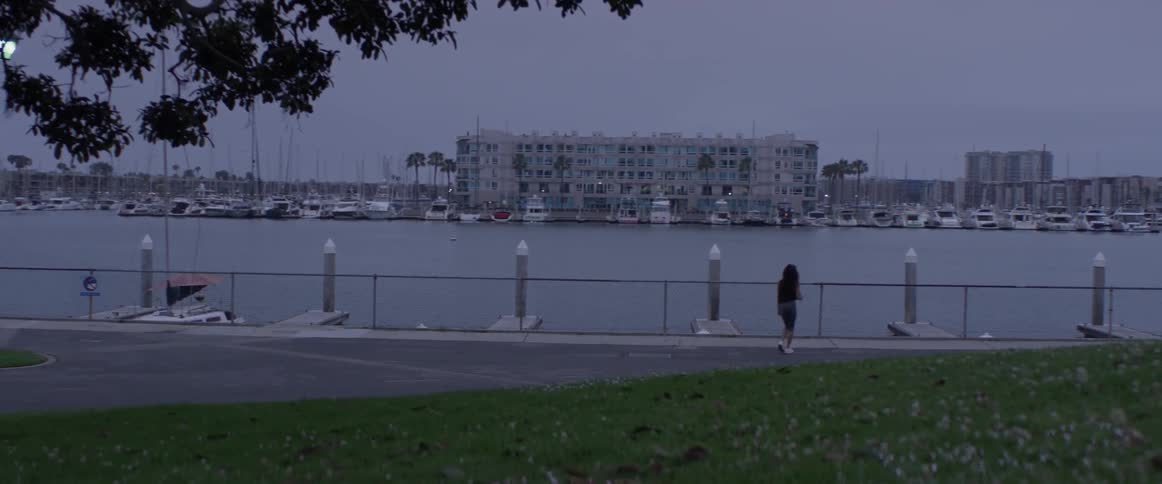 Woman runs near marina at dusk