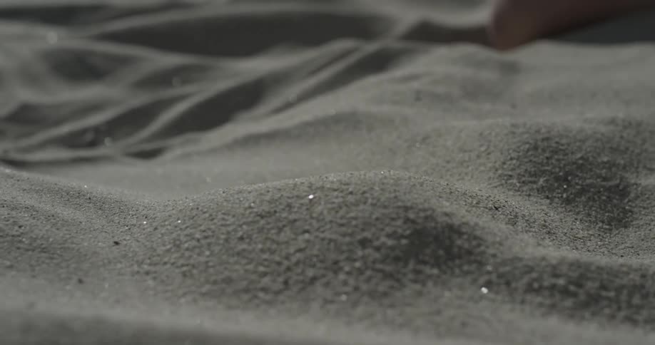 A person scoops up sand and lets it go