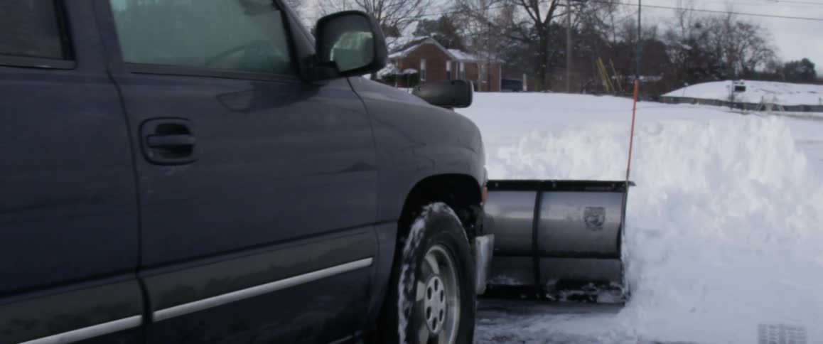 A plow clearing snow in a residential area