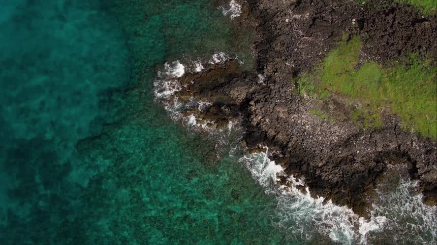 The ocean waves crash onto a rocky shore