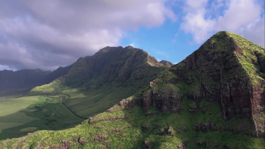 Mountains will grasslands and a cloudy sky