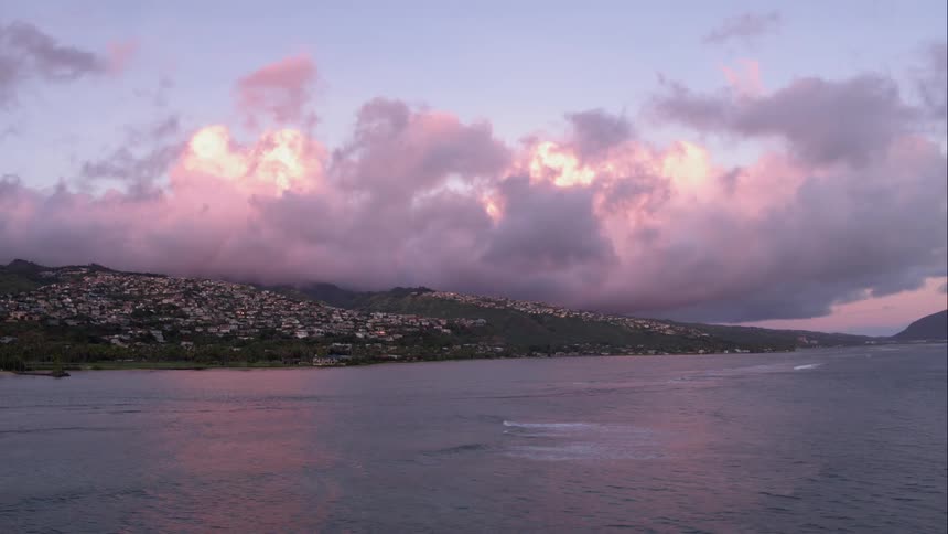 Clouds roll over an island at sunrise