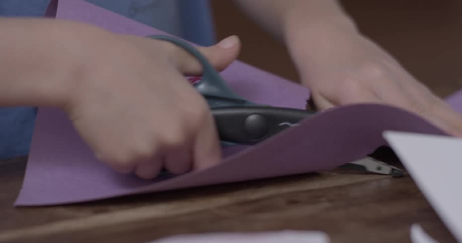 A child using scissors to cut out a piece of paper