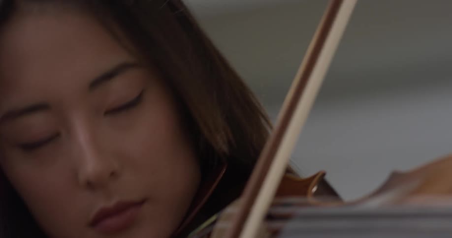 Woman plays a violin with her eyes closed