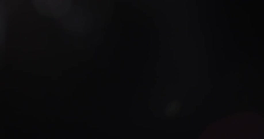 A dark screen slowly lightens as an image comes into focus