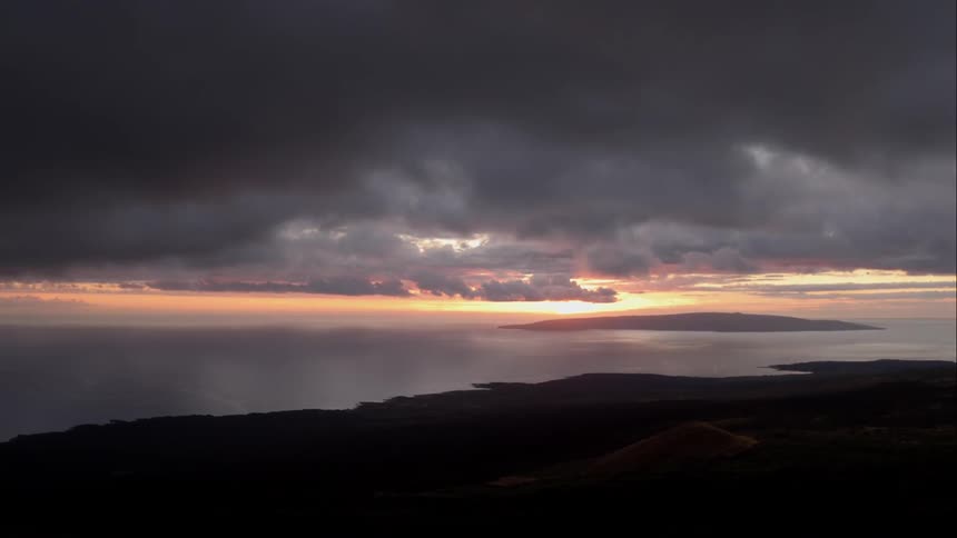 Sun rises over a dark island