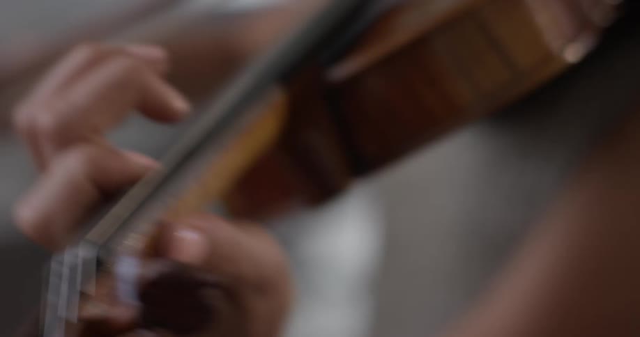 A woman playing a violin in a house