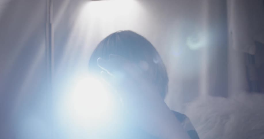 Boy looks over glass ball using a flashlight