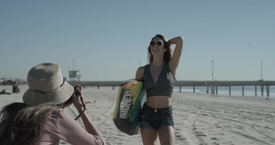 Woman carrying a boogie board on the beach