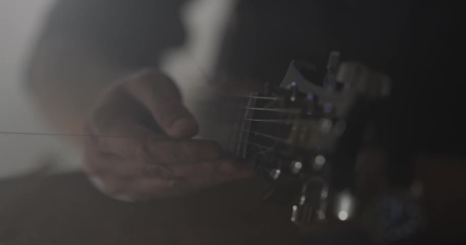 Man Making Guitar In Workshop