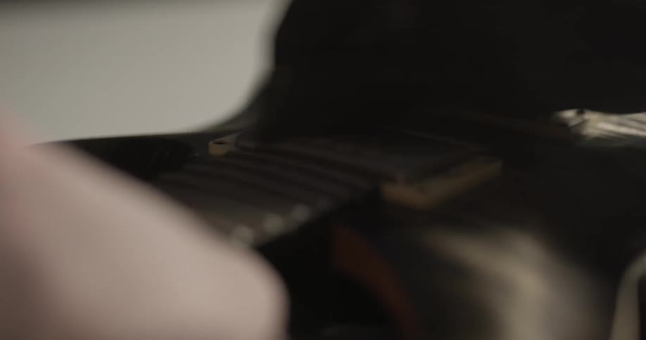 Person rubs down guitar with cloth