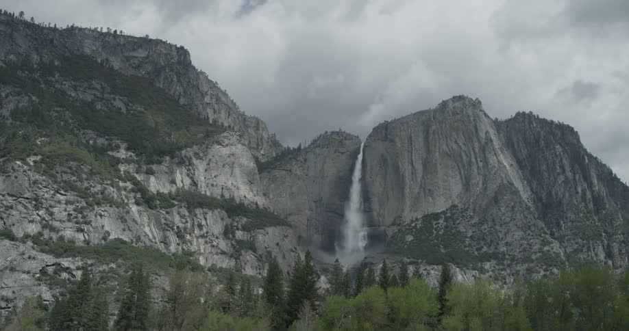 Clouds frame a rushing waterfall