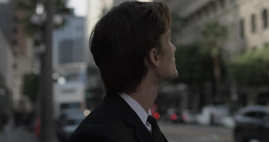 A business man stares up at the city