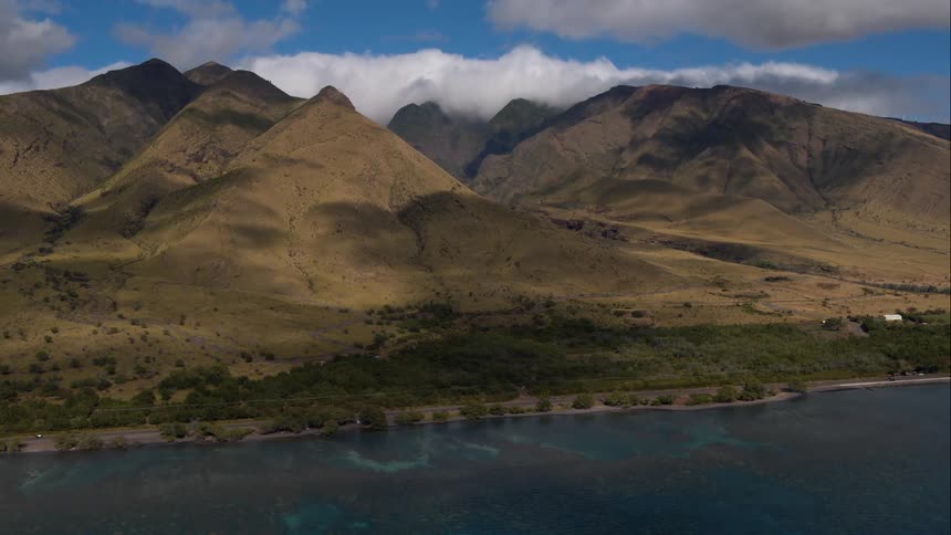 The ocean at the base of some mountains