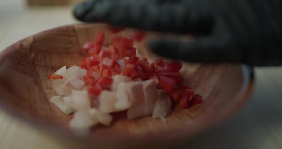 A person is putting ingredients into a bowl