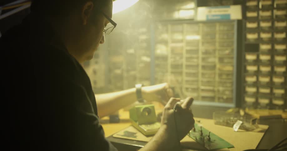 A man is using tools to fix an object