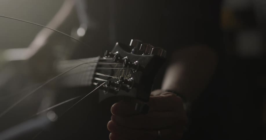 A man is tuning his guitar