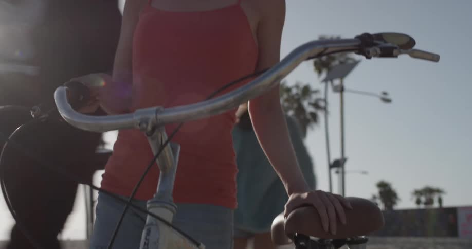 A woman is pushing a bicycle