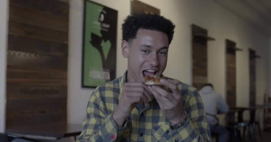 Man eats pizza at a restaurant