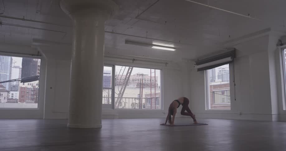 Woman Doing Yoga In Empty Building