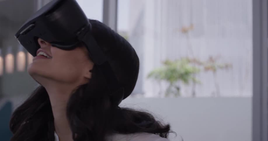 A female indoors with virtual reality glasses on