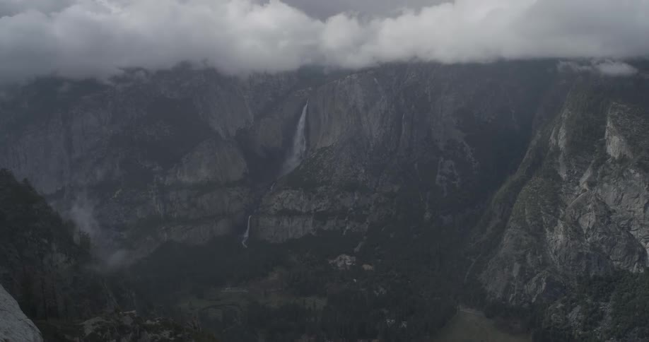 Very large waterfall in a cloud rimmed mountain range