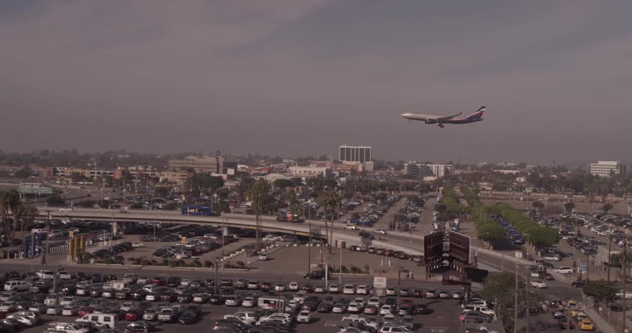 An airplane flies above a busy city