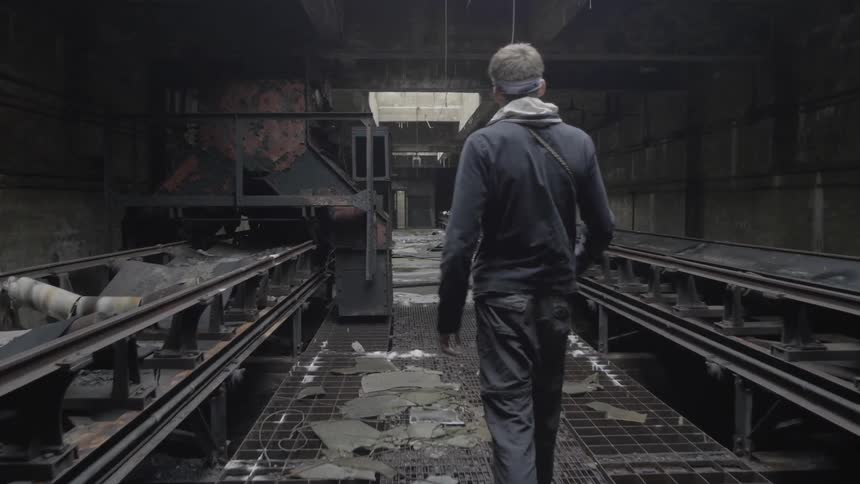 A man is  walking in a burnt down building