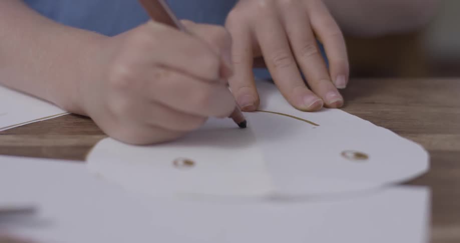 Someone drawing a smiling face on paper