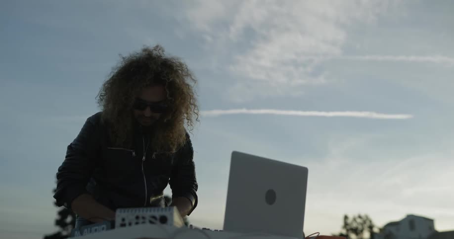 Man playing with dj equipment outside