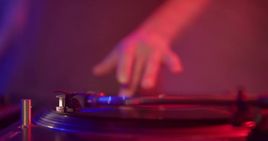 Dj puts record on player at a club